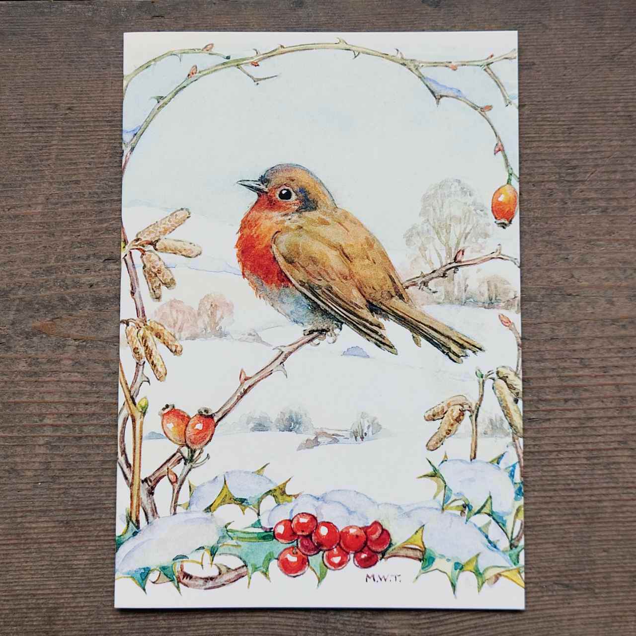 Card with a robin illustration on a snowy background with berries and holly.