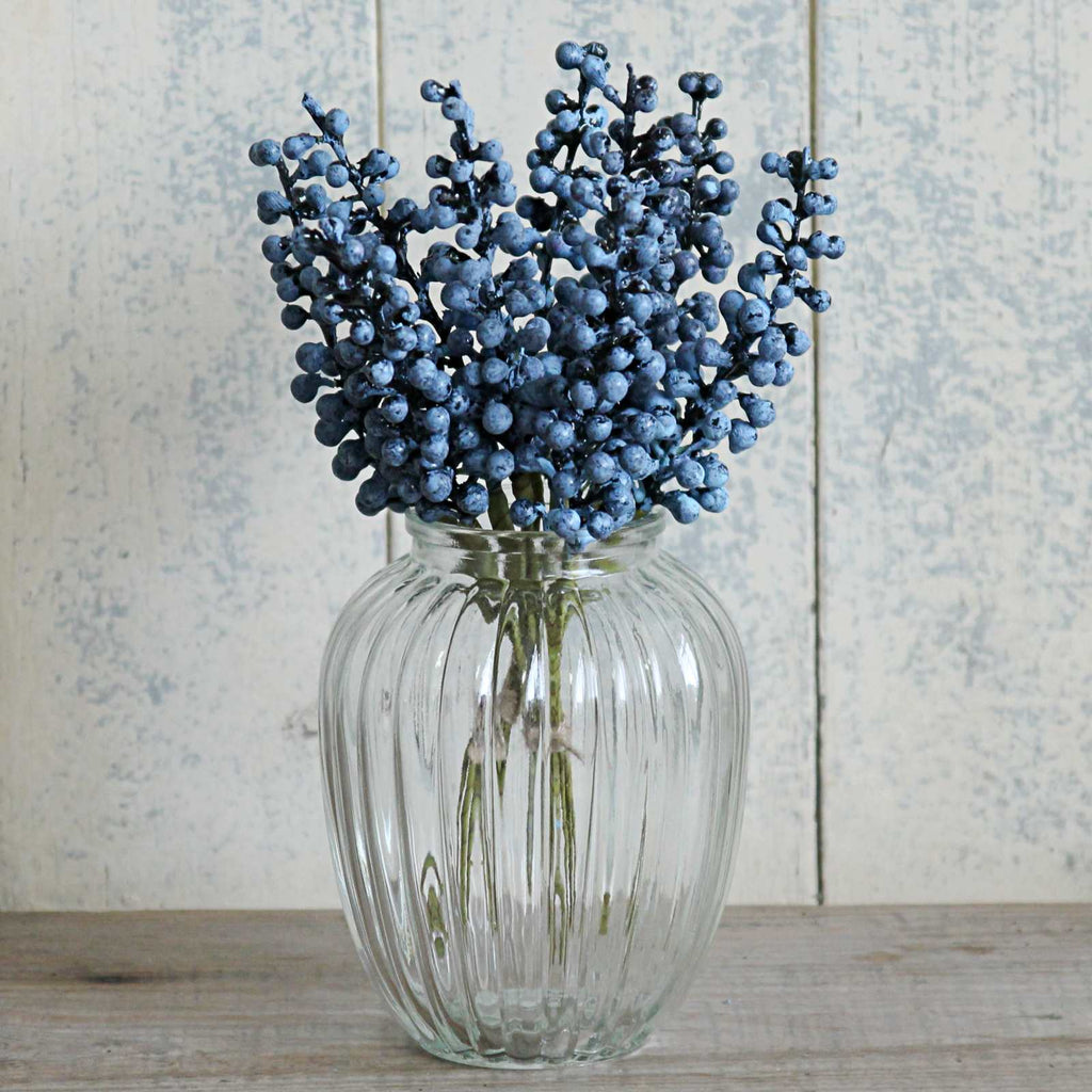 Blue berries in oval ribbed glass vase