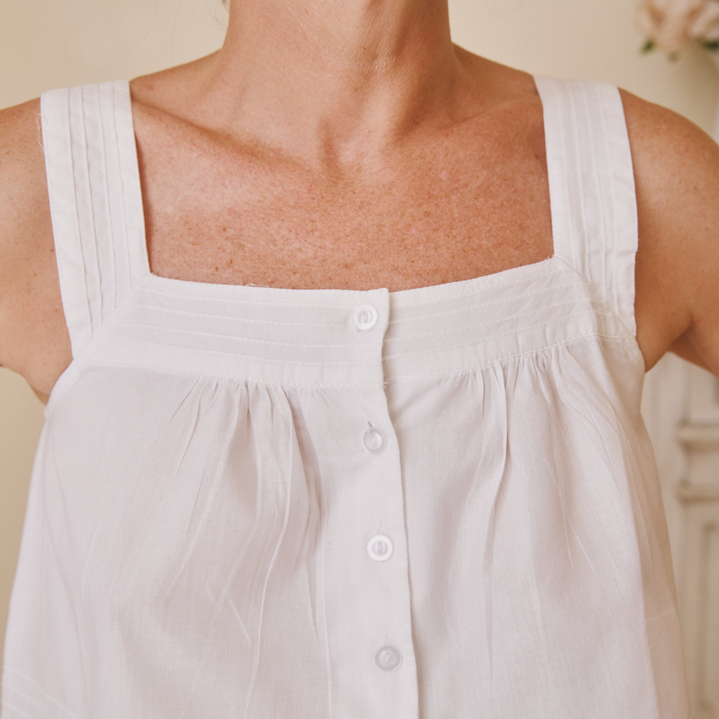 White cotton sleeveless top with buttons