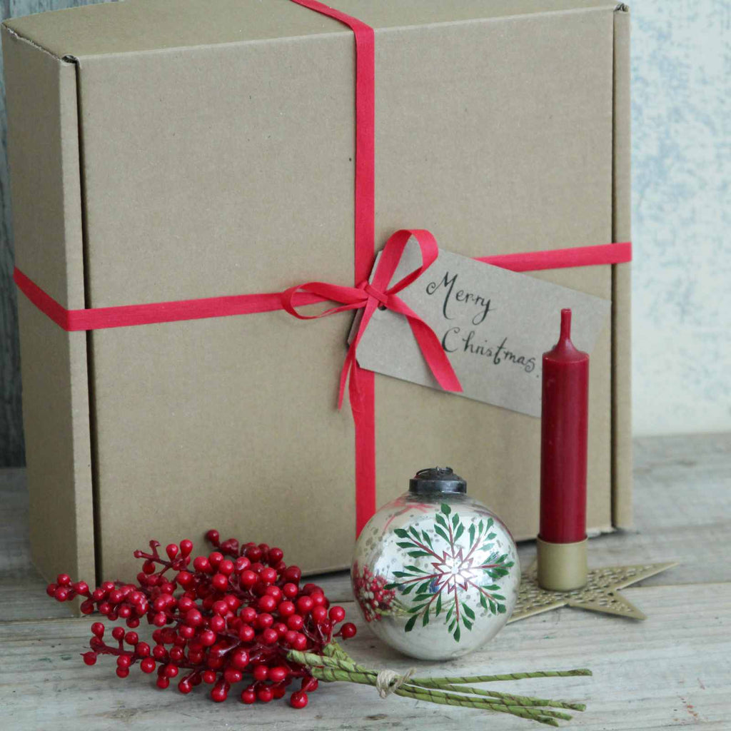 Boxed Gift - Our 'Snowflake' Christmas Gift Box includes a Gold Star Candle Holder and short red dinner candle, a beautiful Painted Snowflake Silver Bauble, and a festive bunch of red berries. This ready made gift will arrive in a gift box tied with a ribbon, with a hand written tag 'Merry Christmas!' 