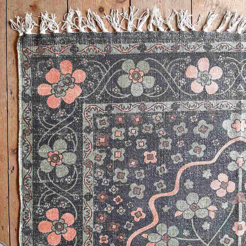 Handwoven cotton rug, faded black floral