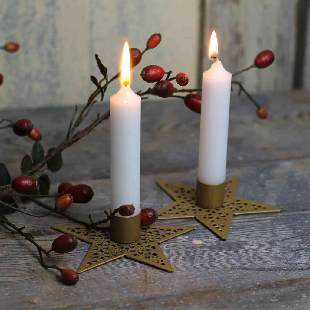candle holder in gold star design with white candles