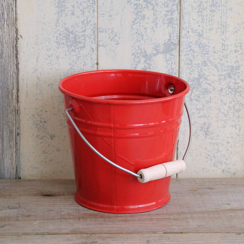 Children's red enamel bucket with wooden handle.
