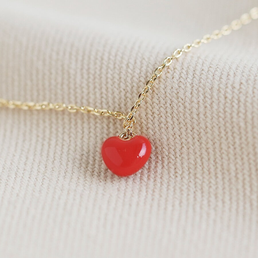 Tiny red heart necklace on a gold chain