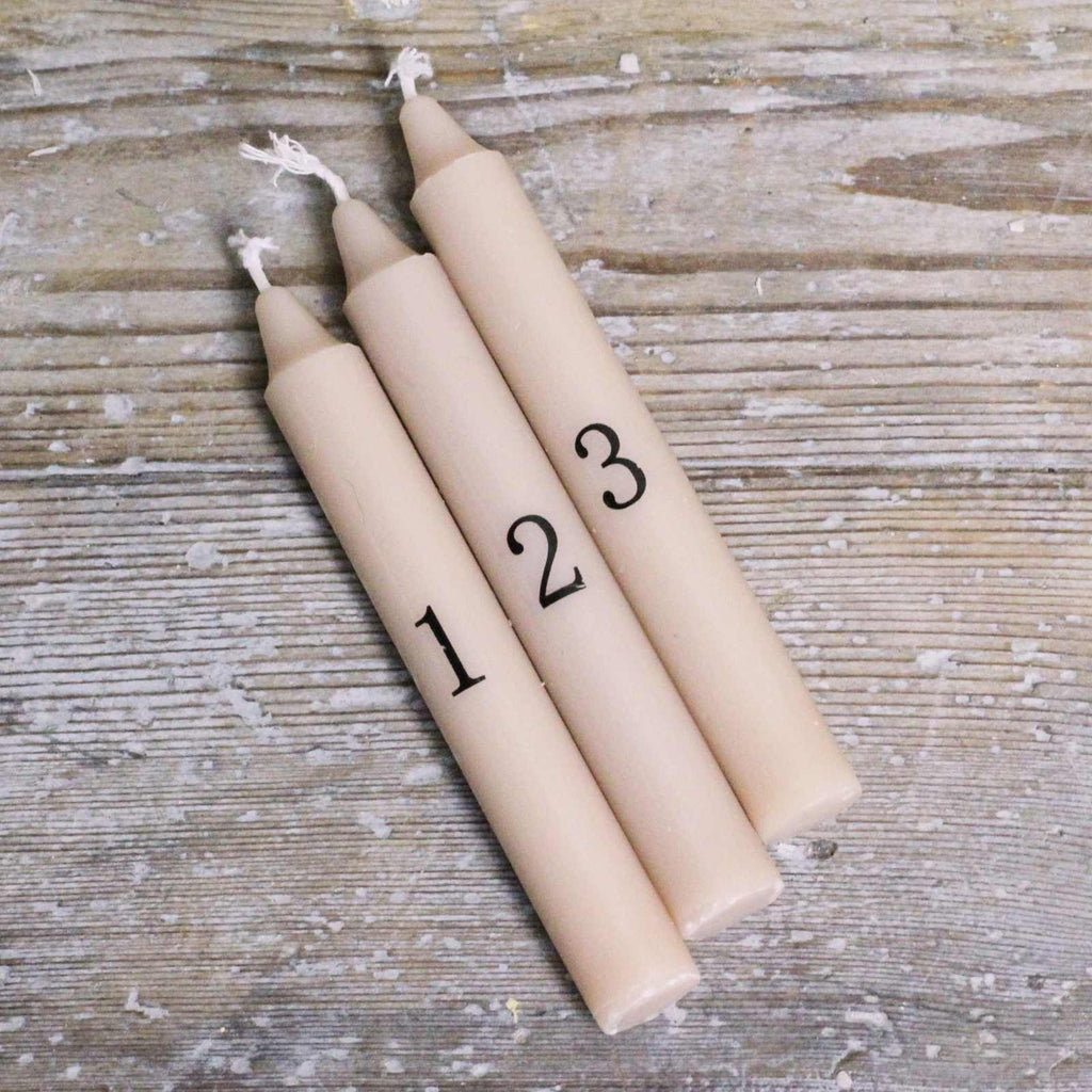 Set of Advent Candles, in a brown craft box. Each taper candle has a black number up to 24