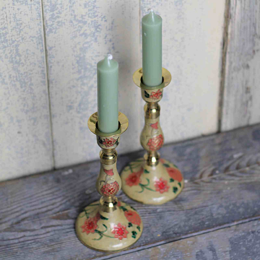 pair of candle stick holders with enamelled floral pattern and dinner candles