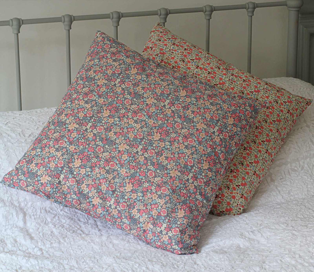 vintage style cushion in lavnder floral pattern on bed
