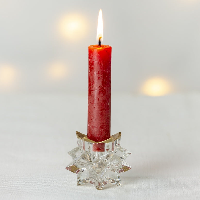 red candle in glass candle holder shaped like a star for Christmas