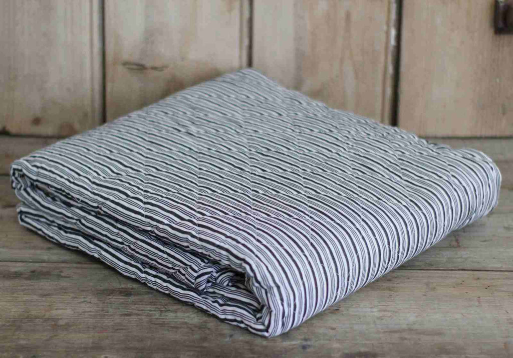 Quilted bedspread with black stripe folded