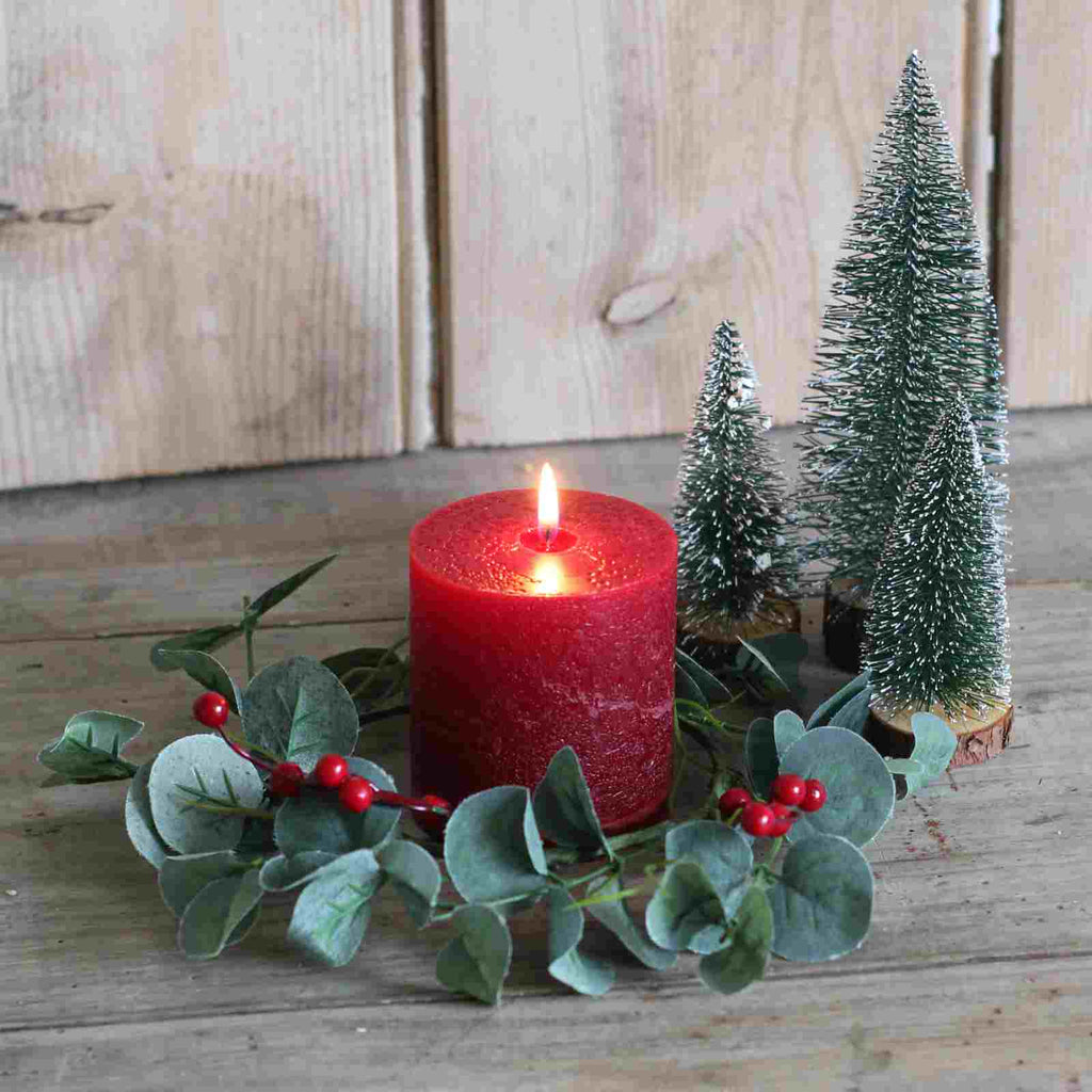 candle holder ring with red berries and eucalyptus with Christmas decorations
