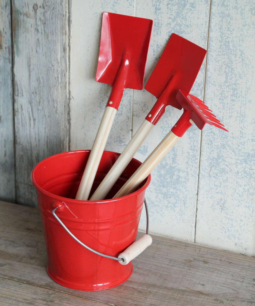 Red enamel and wood gardening tools for children with red enamel bucket