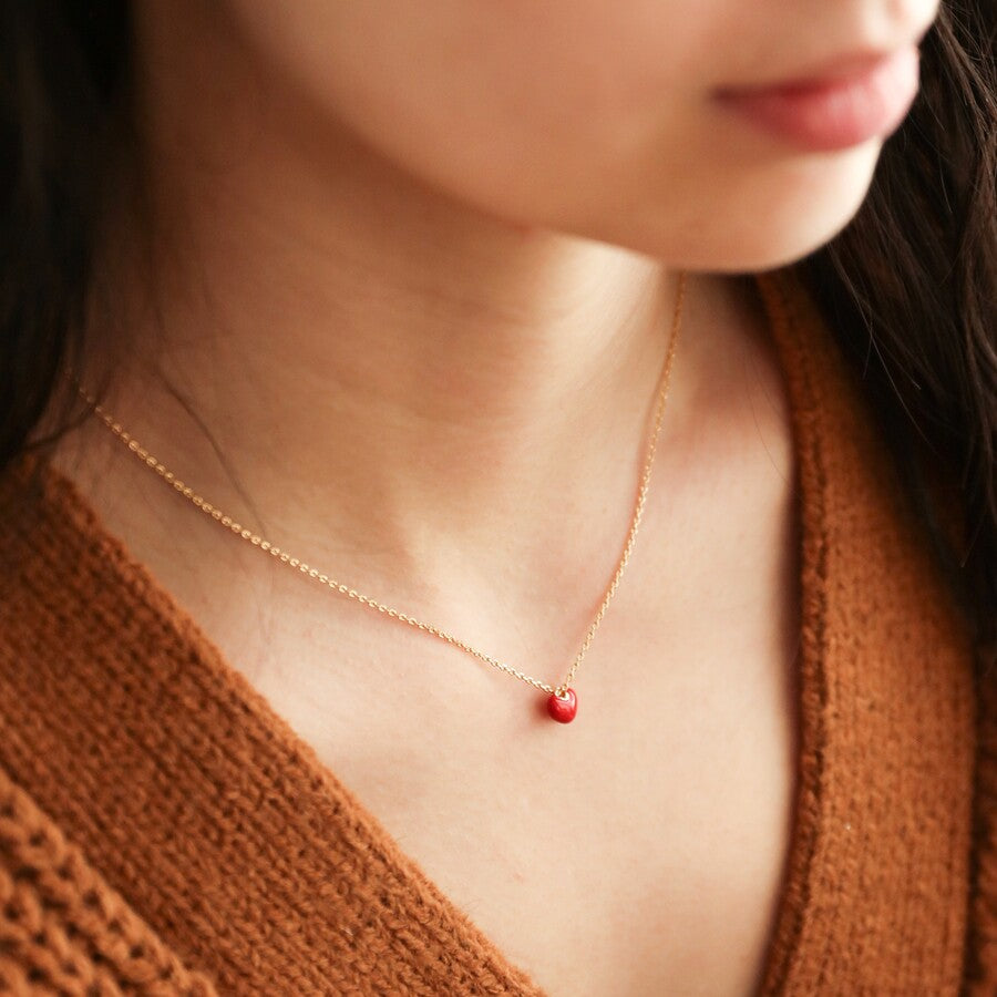 Tiny red enamel heart necklace with a gold chain